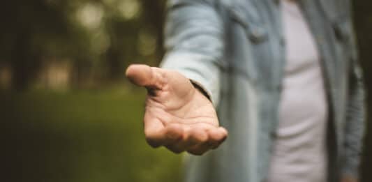 Ausgestreckte Hand in Richtung Kamera