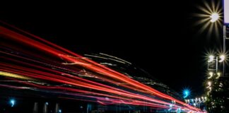 Wie viel Speed erträgt ein Mann? Langzeitbelichtung: Die roten Lichter eines Autos auf der Straße.