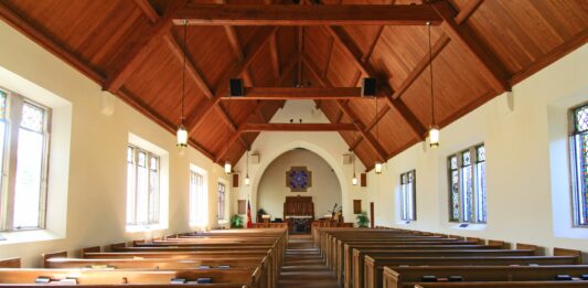 leere Kirche, Saal mit leeren Sitzbänken aus Holz