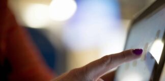 Kirche startet Pilotprojekt: Predigt auf Knopfdruck Eine Frau tippt auf einen Touchscreen.