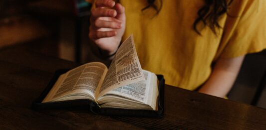 Frau blättert in Bibel