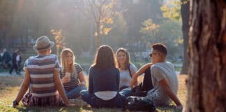 Taizé: Jugendtreffen sind wieder möglich 5 junge Menschen sitzen auf einer Wiese im Kreis