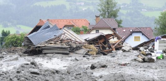 Ein durch Hochwasser zerstörter Schuppen und im Vordergrund jede Menge Schlamm.