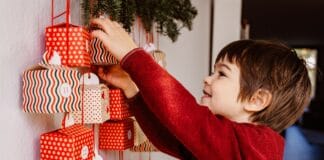 Adventskalender: Weihnachtsfilme mit Playmobil nachgespielt Ein kleiner Junge öffnet strahlend einen Adventskalender.