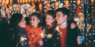 Jesus soll die Losung sein Eine Familie mit zwei Kindern hält Wunderkerzen in den Händen und feiert Silvester.