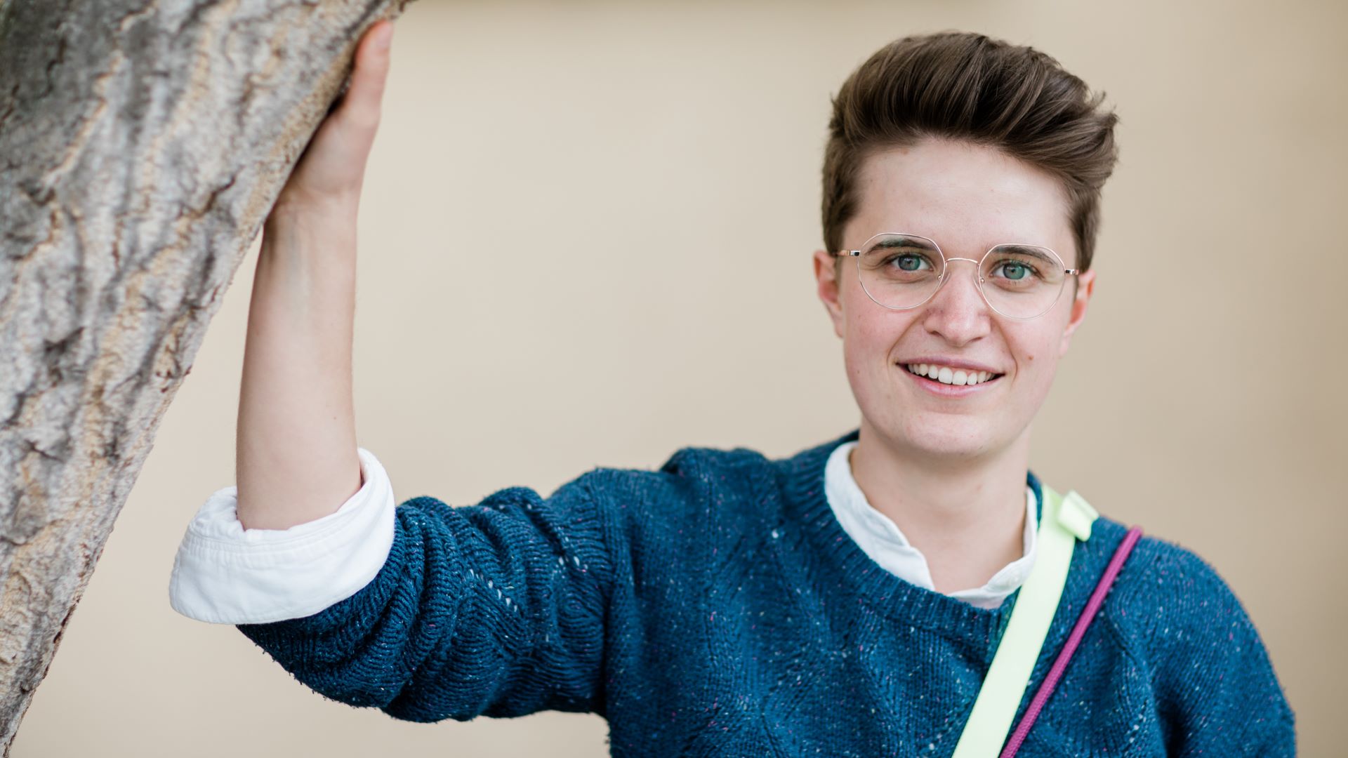 Anna-Nicole Heinrich, Präses der EKD, lehnt sich an einen Baum an.