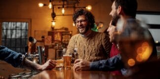 Bierbrauen im Pfarrhaus Eine Gruppe Männer trinkt Bier in einer Bar.