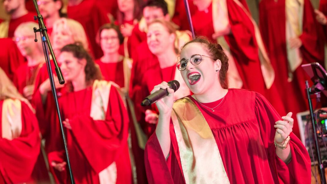 Ein Chor singt in roten Roben auf dem Gospelkirchentag.