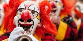 Christen, legt die Kostüme ab! Ein Clown spielt Trompete.