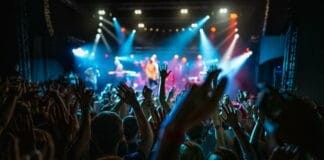 Schweiz: Jugendfestival CREA! findet zum letzten Mal statt Eine Menschenmenge tanzt mit erhobenen Armen vor einer beleuchteten Bühne.