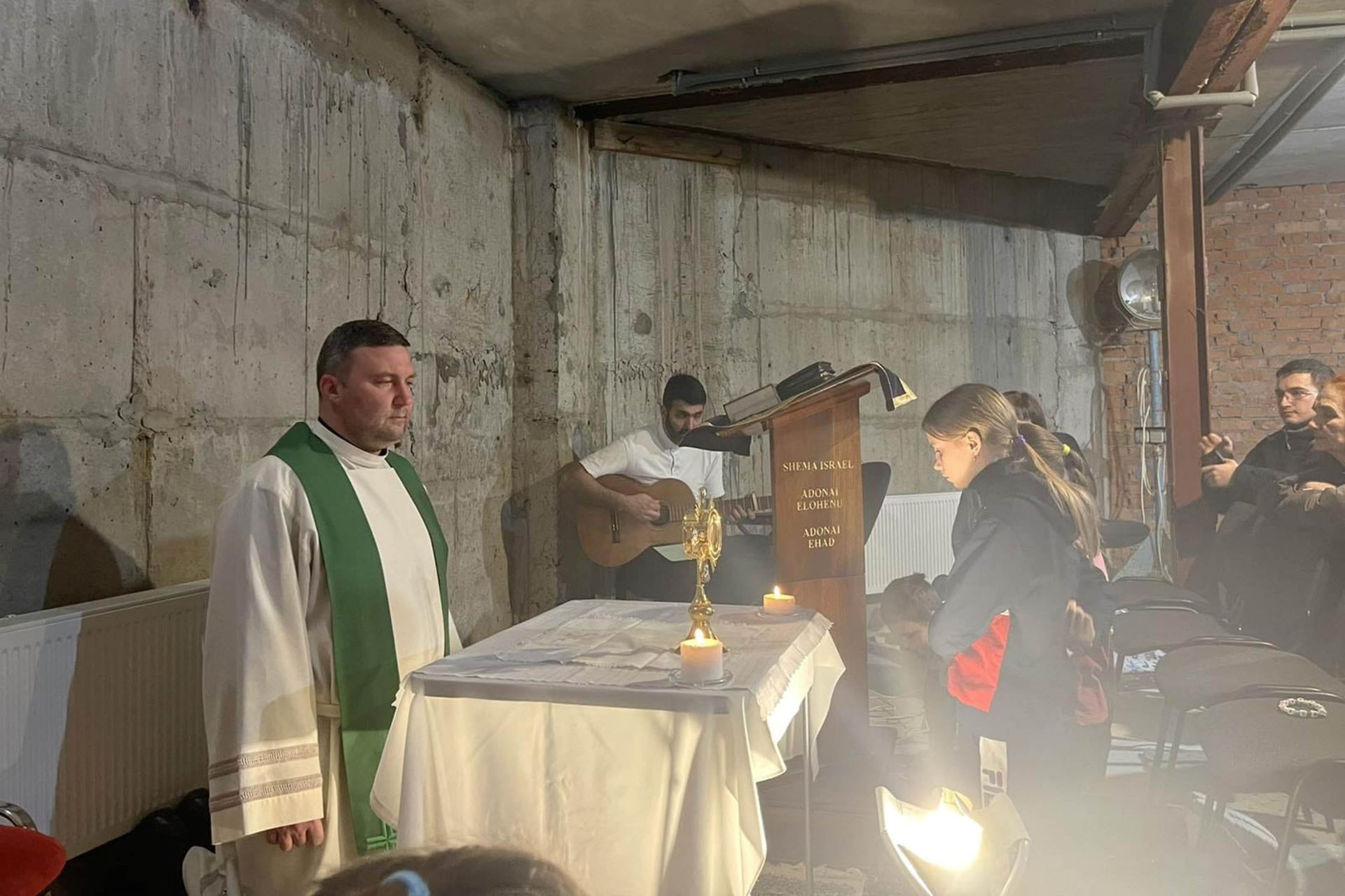 Menschen beten und singen in einem Luftschutzkeller.