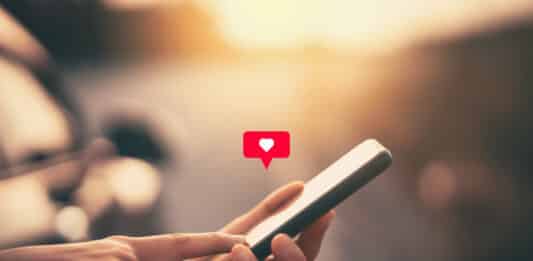 hand hält Smartphone mit Herz-Symbol