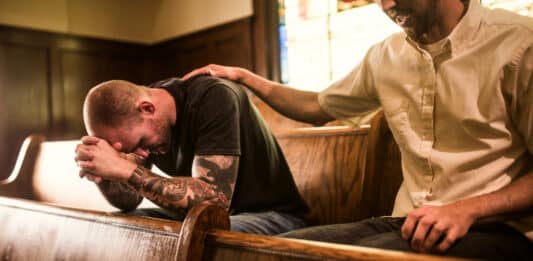 Männer beim Gebet in einer Kirche Seelsorge