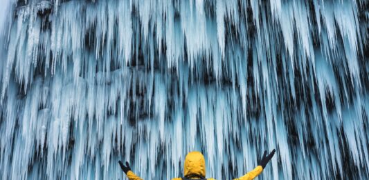 Wasserfall Man gelbe Jacke Eis Winter