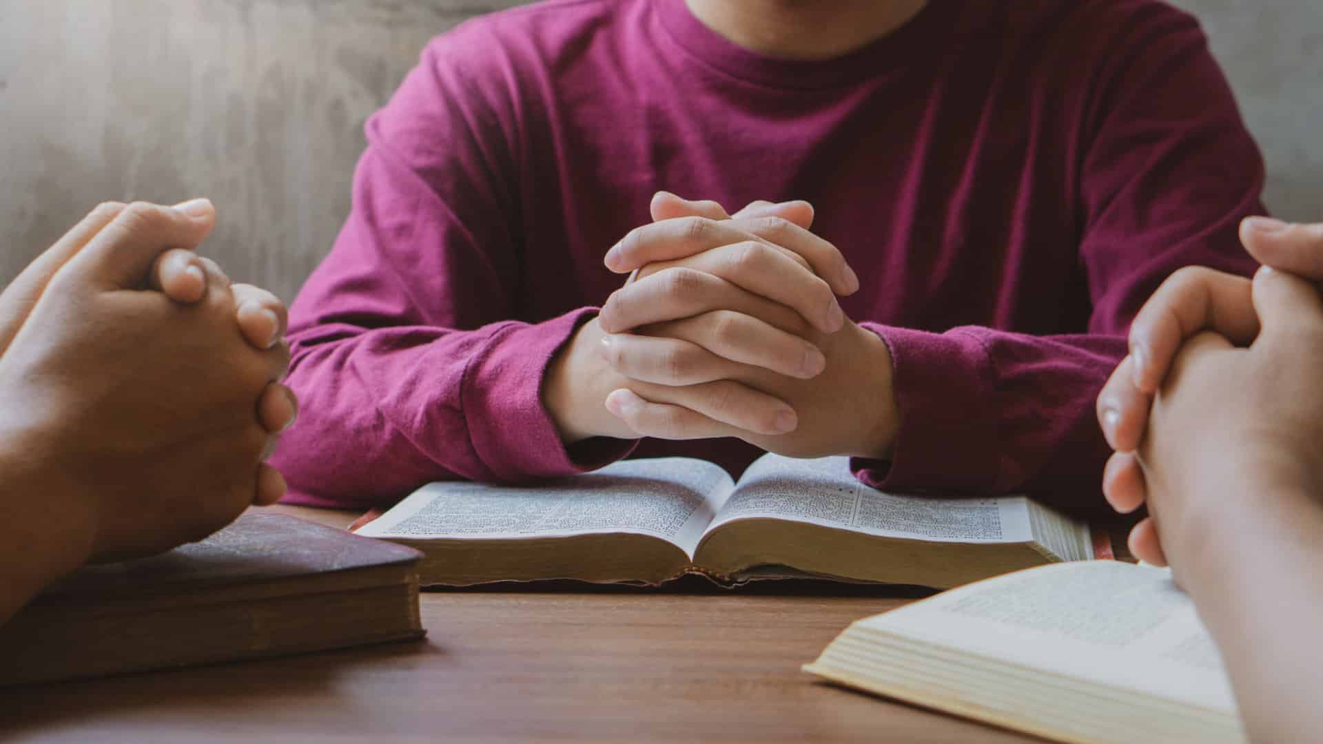 Menschen beim gebet am Tisch Bibel