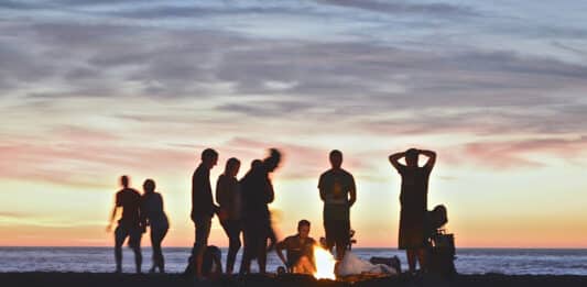 Junge Menschen am Lagerfeuer am Strand