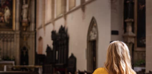 Frau in leerer Kirche