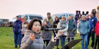 SPRING: Sonnenaufgänge für die Seele Theologieprofessorin Mihamm Kim-Rauchholz spricht im Freien in ein Mikrofon.