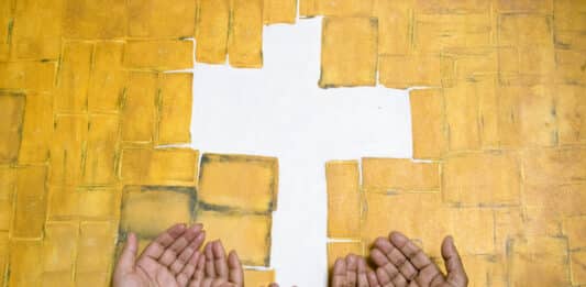 Offene Hände unter dem Kreuz