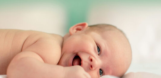 Fröhliches Baby liegt auf der Seite