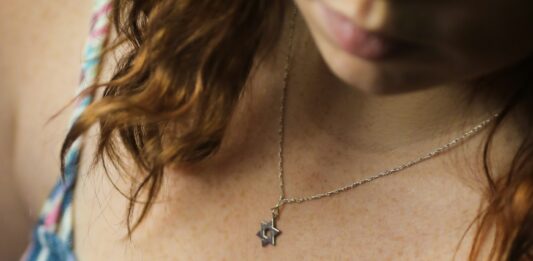 Eine Frau trägt eine Kette mit einem Davidstern um den Hals.