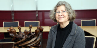 Norddeutsche Mission: Abschied vom Missionsbegriff Die evangelische Pastorin Heike Jakubeit in der Zentrale der Norddeutschen Mission, neben einer Skulptur von Holzmännchen, die mit ihren Händen verbunden sind