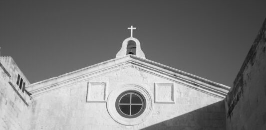 aufwärts Fotografierte Kirche im mediteranen Stil. Schwarz Weiß mit diagonal verlaufenden Schatten