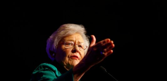 Kay Ivey ganz im Schatten, sie gestikuliert um etwas zu erklären