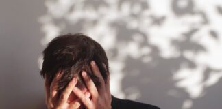 Studie: Religionslosigkeit fördert Angststörungen Mann verdeckt sein Gesicht