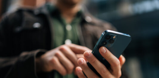 Mann tippt auf einem Smartphone