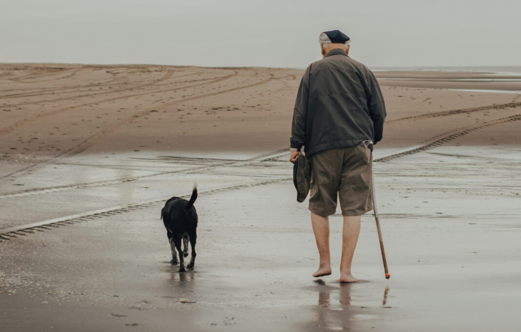 Alter Mann mit Hund am Meer