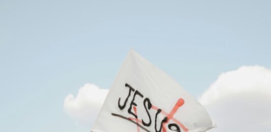 Ein Mädchen schwenkt eine Fahne, auf der Jesus steht.