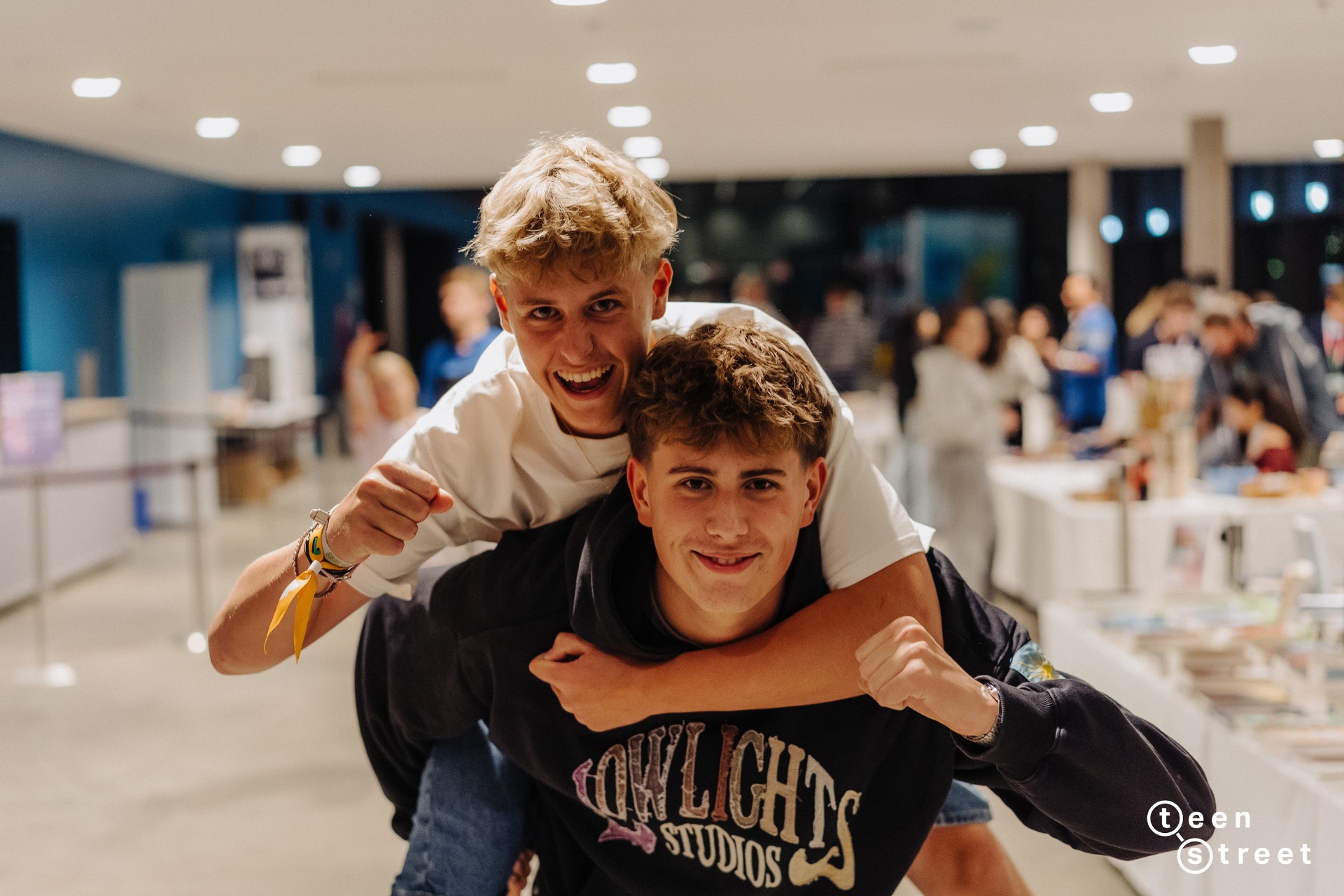 Zwei Teenager lachen in die Kamera.