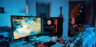 Gott liebt Gamer Ein junger Mann spielt etwas auf seinem Gaming PC.