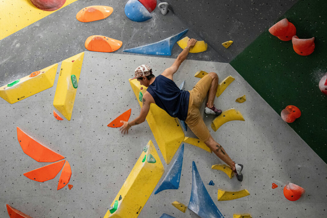 Junger Mann beim Bouldern in Kletterhalle