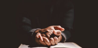 Bischof warnt: Religionsfreiheit weltweit eingeschränkt Jemand betet in einer dunklem Kammer.