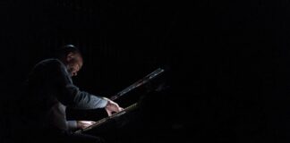 Geistliche Musik – von der Schönheit des Geheimnisvollen Ein Mann spielt im Dunkeln Klavier.