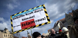 Der böse Islam? Wie Feindbilder Menschen radikalisieren Ein Mann hält bei einer Demo ein Schild mit der Aufschrift "Islam raus." hoch.