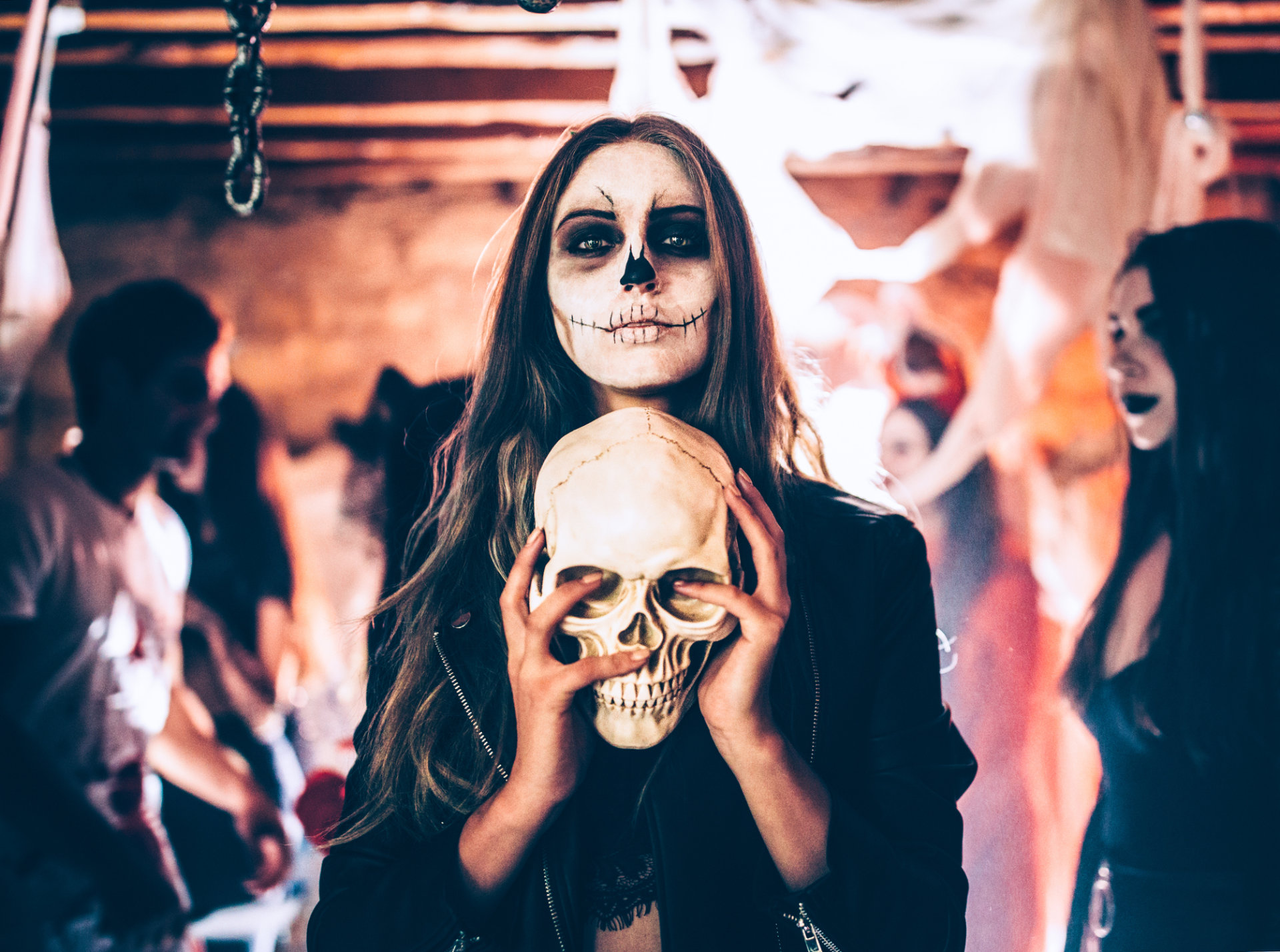 Junge Frau mit Totenschädel bei Halloween-Party